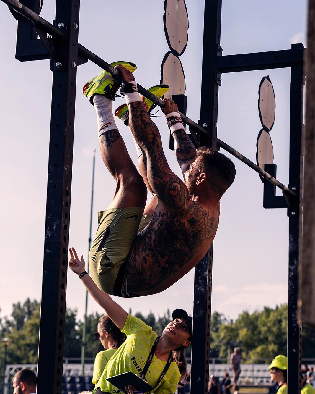 Athlete performing toes-to-bar while a judge watches at Nike Metcon FortFight
